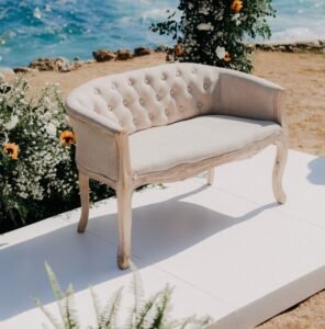 a white bench sitting on top of a sandy beach